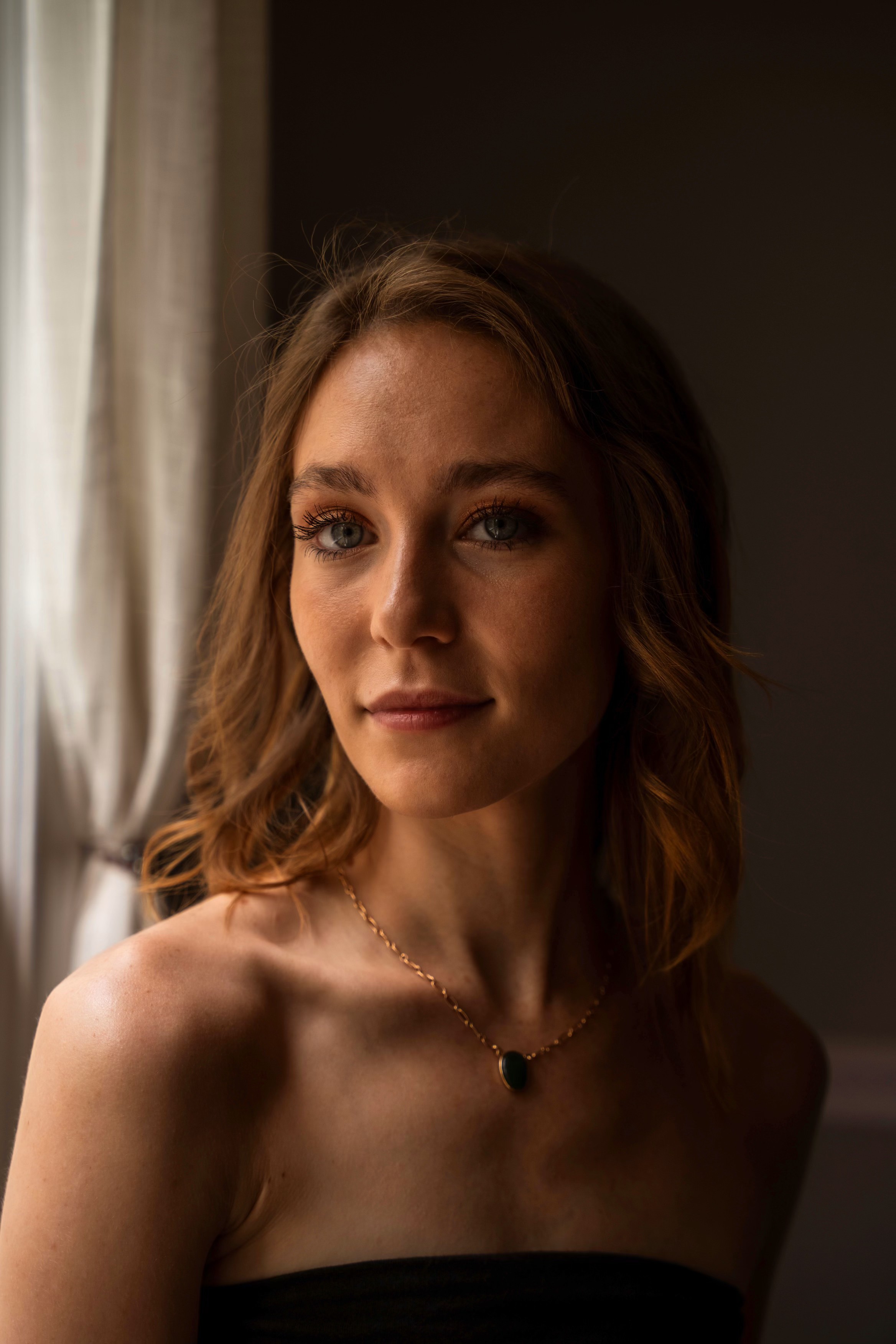 Becca in a warm, window-lit portrait